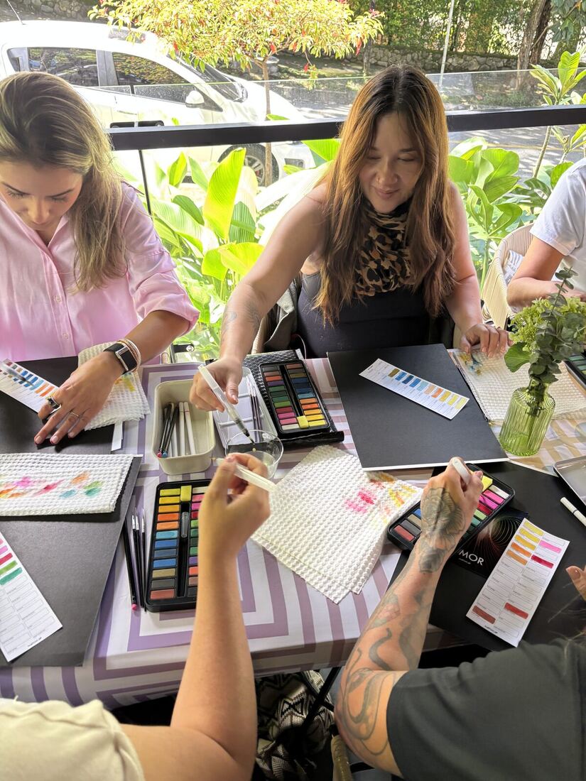 Mesa del taller con pinturas y frascos de agua